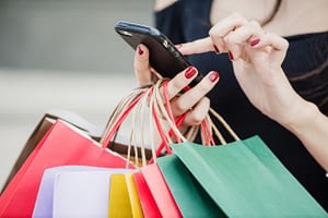 woman-with-shopping-bags-holding-smartphone_23-2147652180